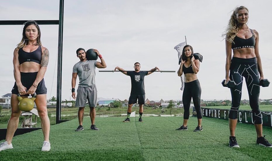 Para member Empire Fit Club Bali berpose sambil mengangkat alat fitness